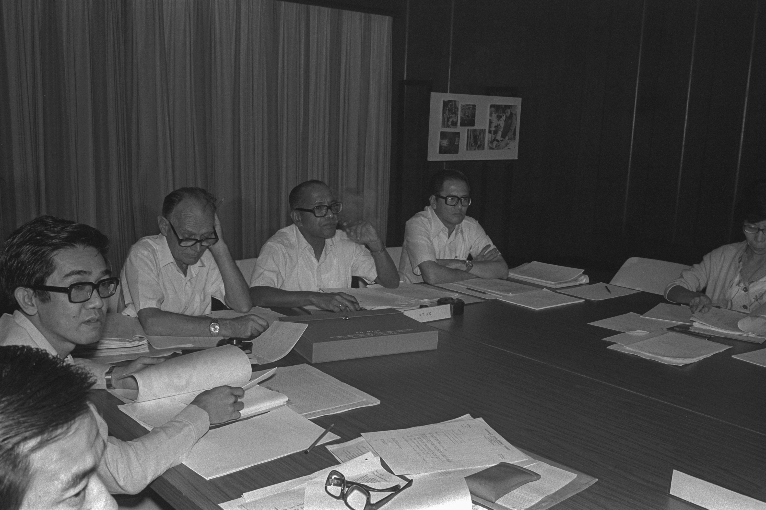 Image shows a group of men sitting at a table.