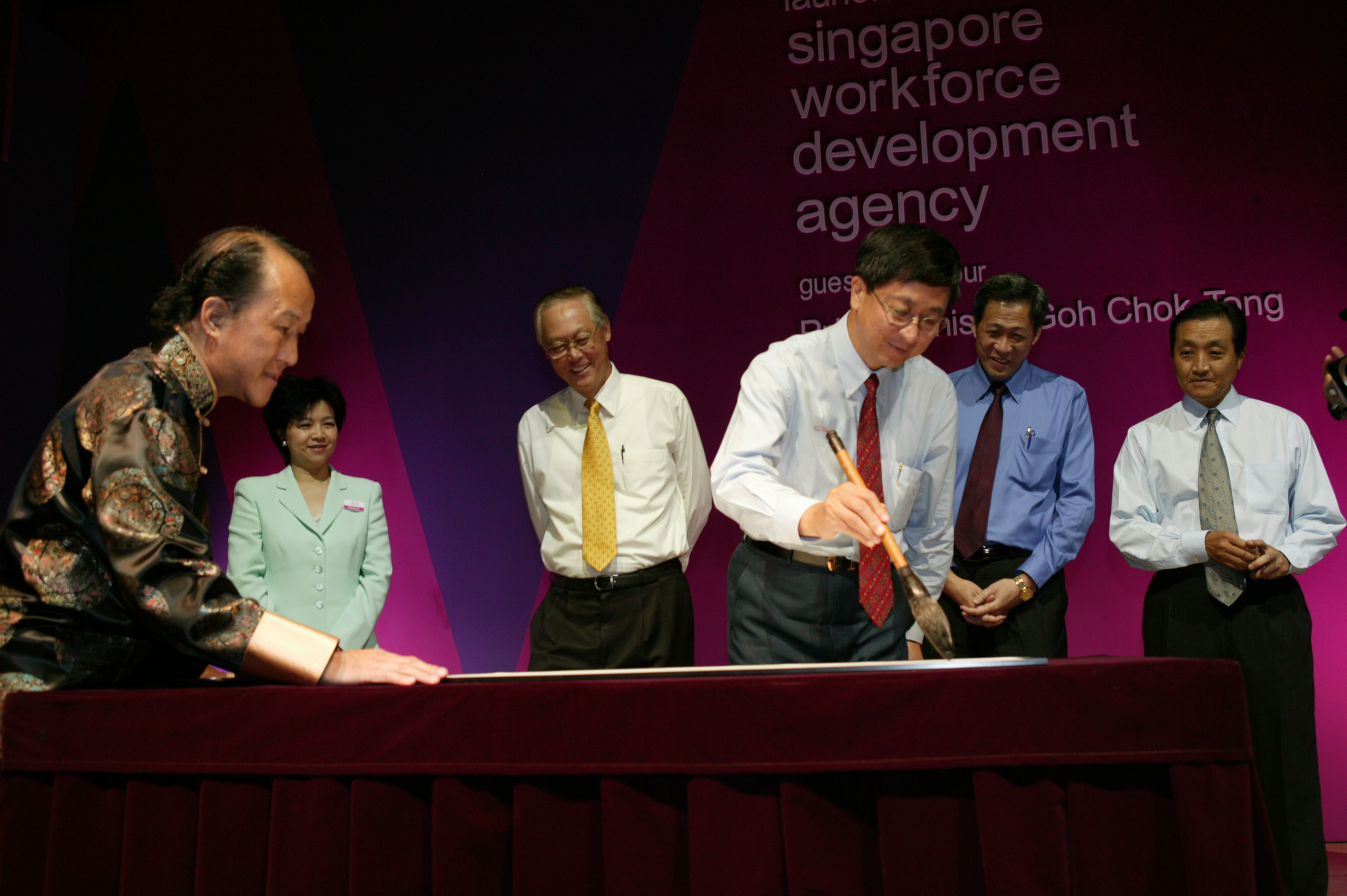 Image shows a group of men standing on a stage. 